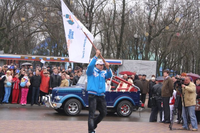 Олимпийский флаг в руках у Алексея Воеводы, бронзового призера Олимпийских игр 2010 года в Ванкувере