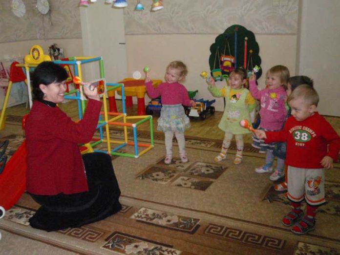 Воспитатель М.С. Ошкина с малышами своей группы